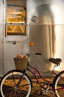 Silver airstream trailer with old-fashioned cruiser bike leaning against it